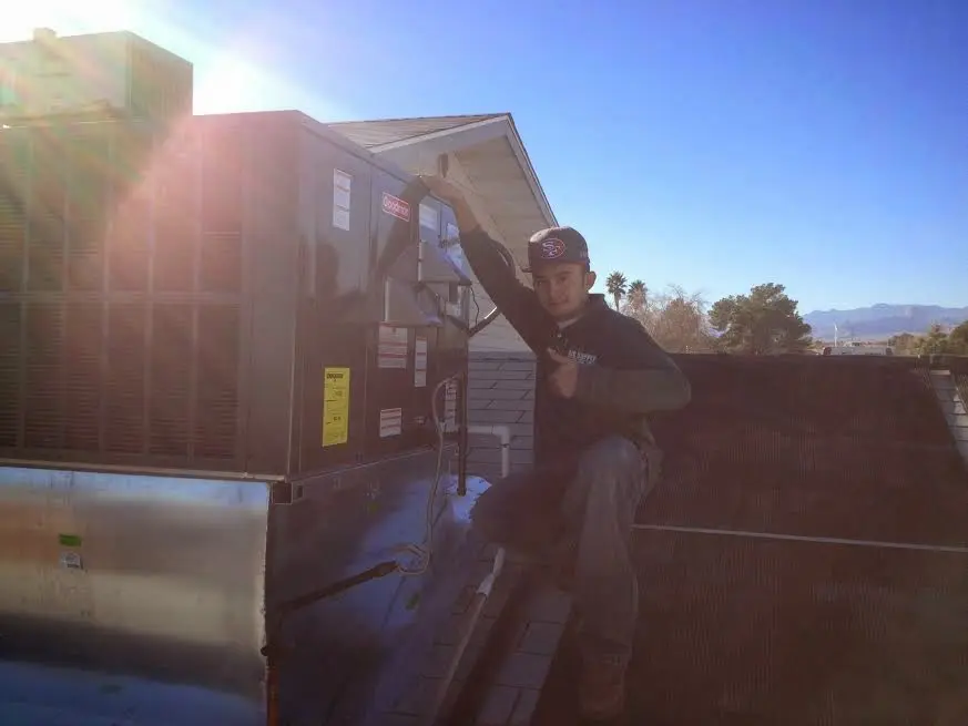 HVAC technician performing HVAC Inspection on a rooftop unit in North Smithfield
